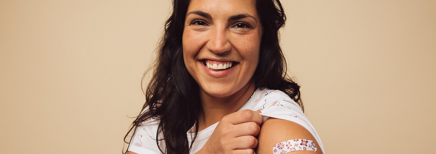 Photo of woman showing off her bandaid after getting her flu shot.