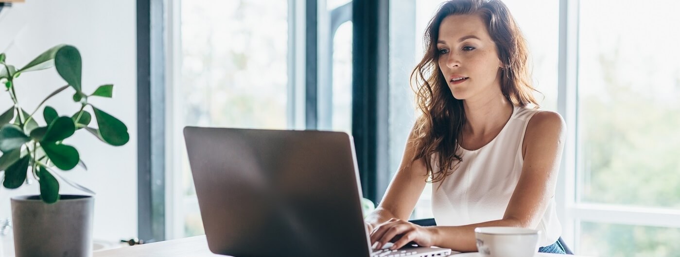 Image of woman looking up information on her computer at home.