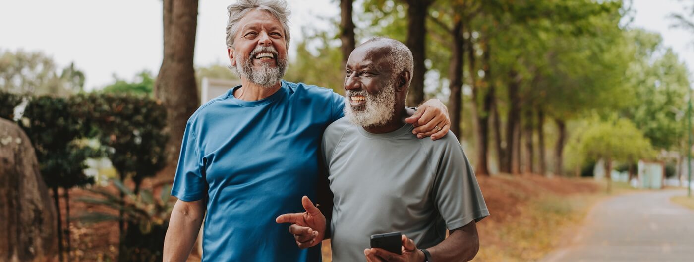Senior men walking and laughing in the park.