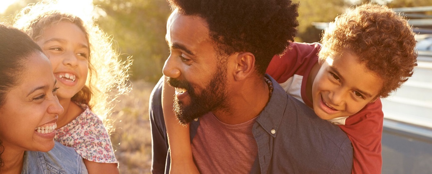 Photo of laughing family outdoors.