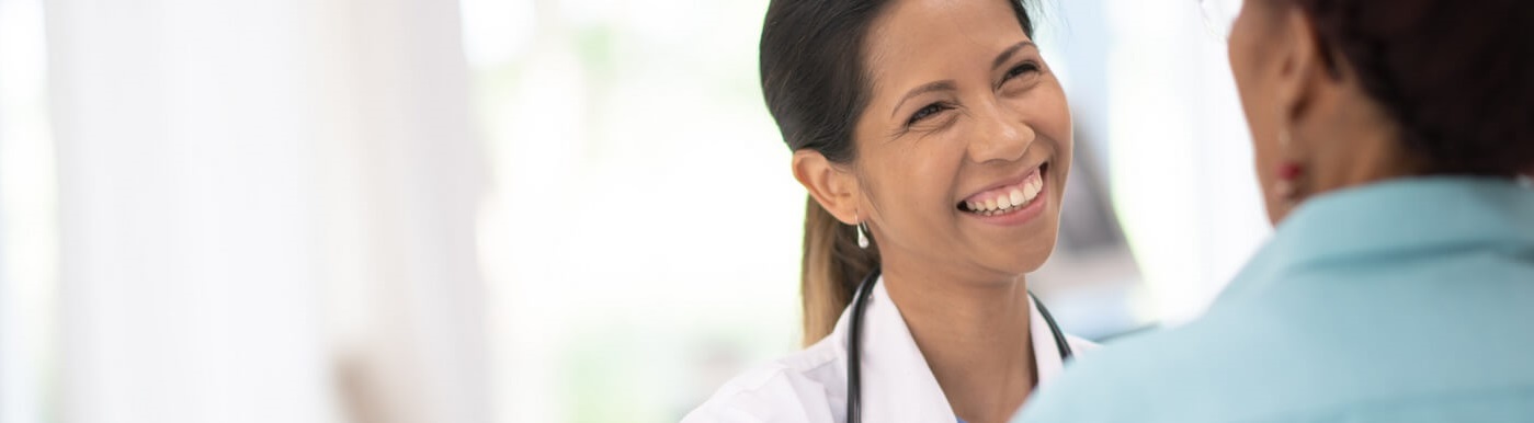 Photo of smiling doctor speaking with patient.