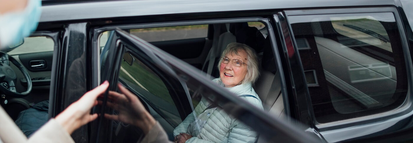 Elderly woman in car getting ride to doctor appointment.