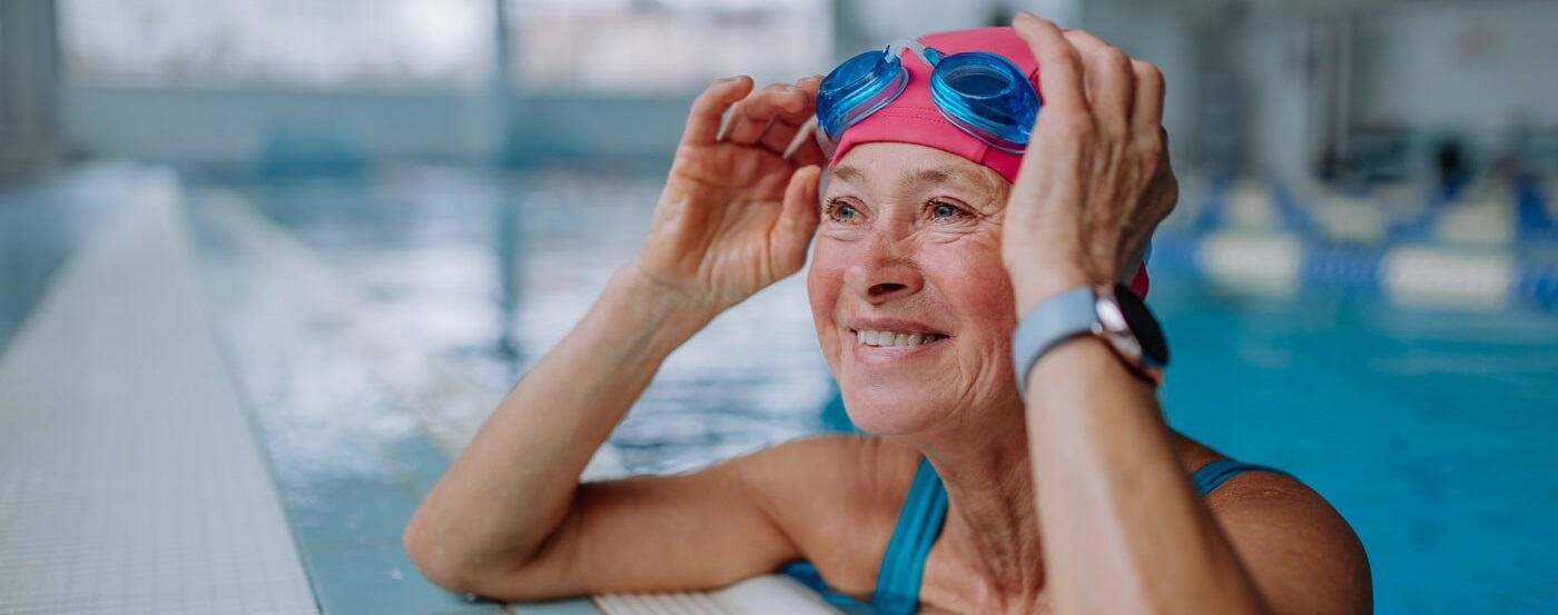 Senior woman swimming at rec center.