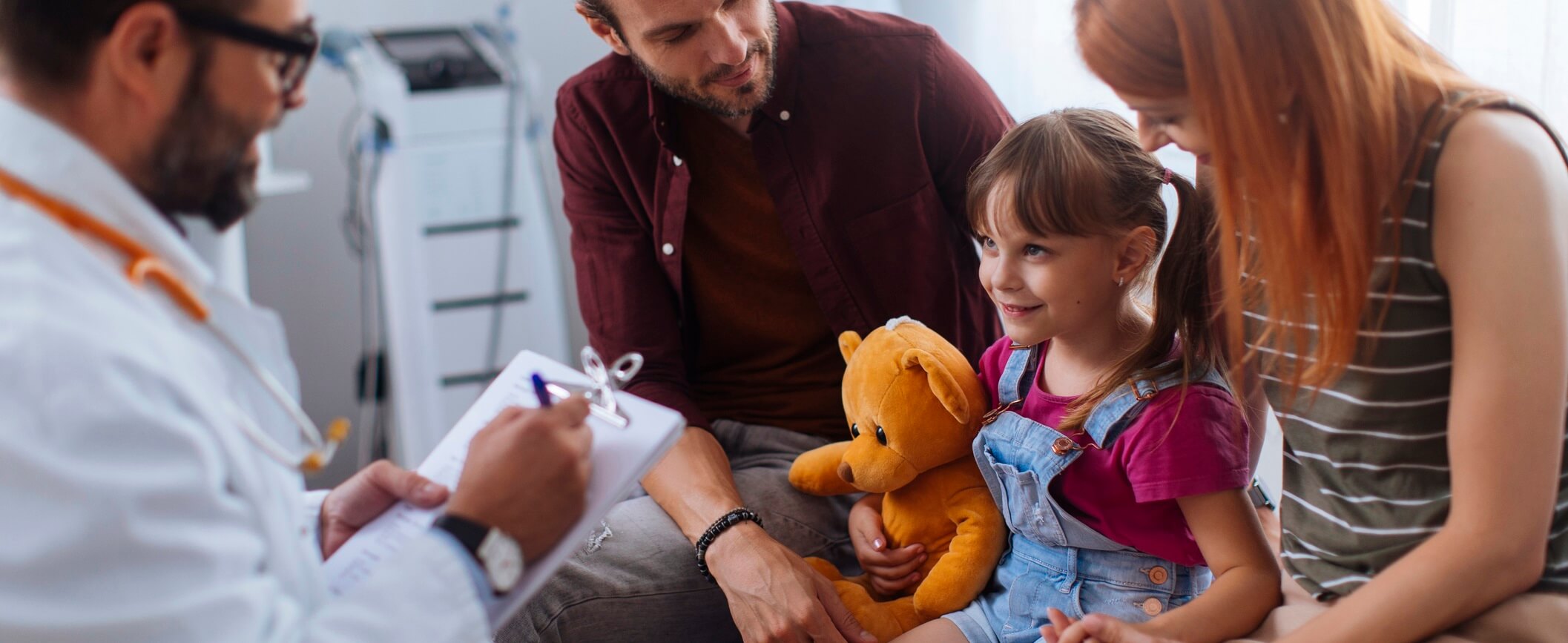 Photo of child with parents and pediatrition.