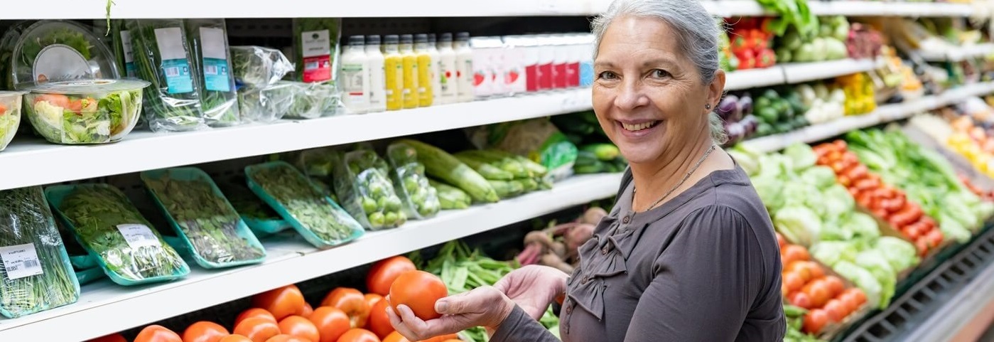 Senior woman shopping produce section in grocery store