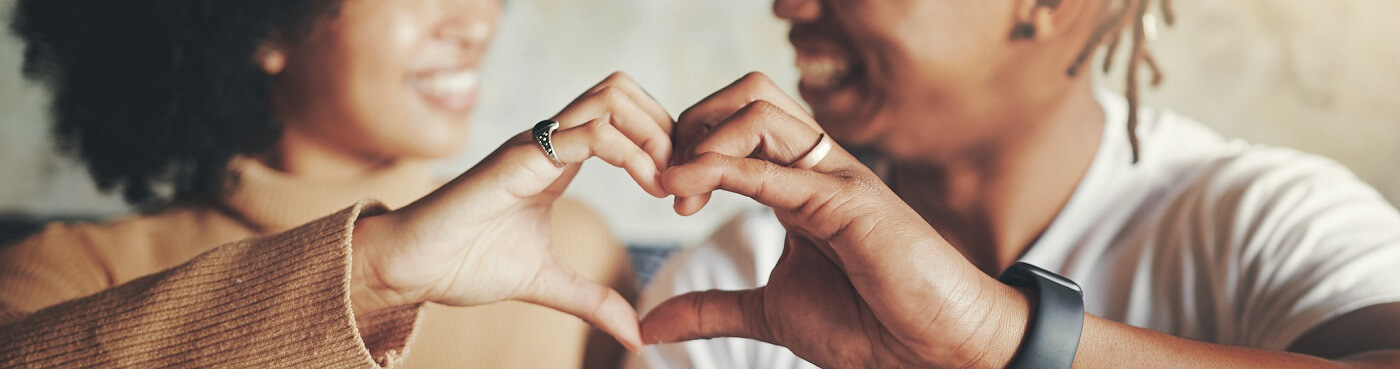 smiling people making heart shape with hands.