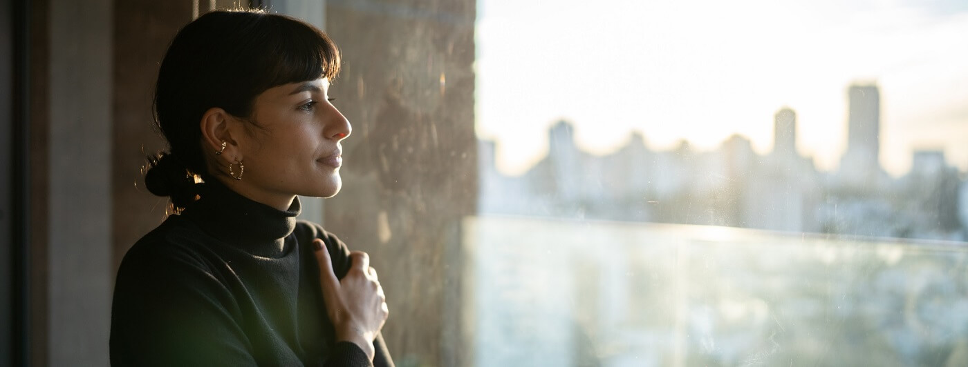 Photo of woman looking thoughtfully out a window.