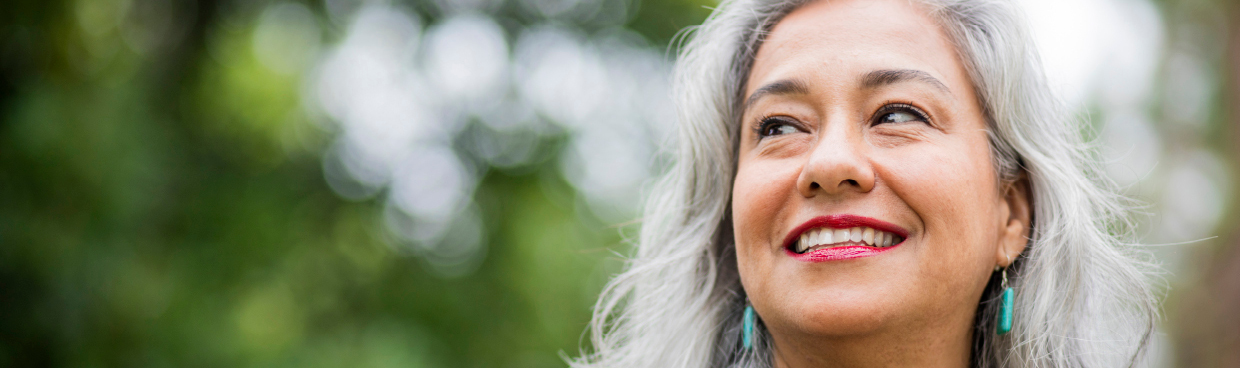 a woman smiles in an outdoor setting