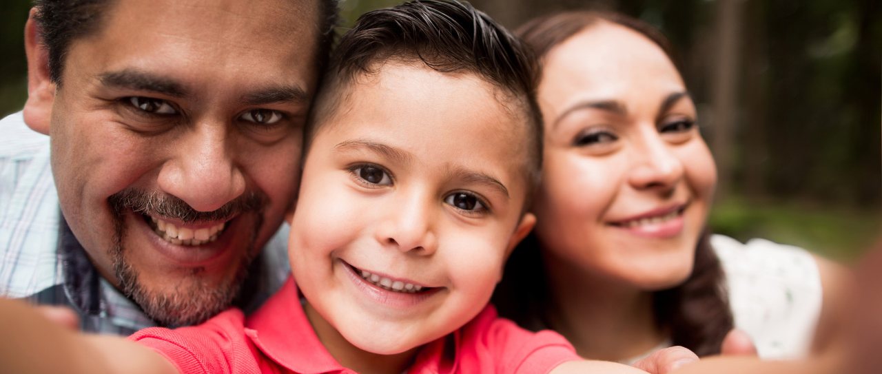 A young boy accompanied by his parents in a park