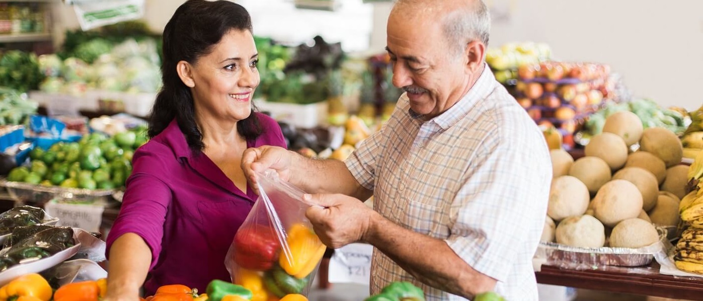 Senior man grocery shopping in produce department.