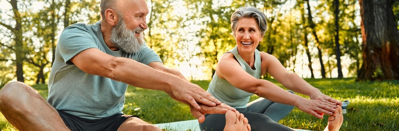 Active seniors doing yoga outdoors
