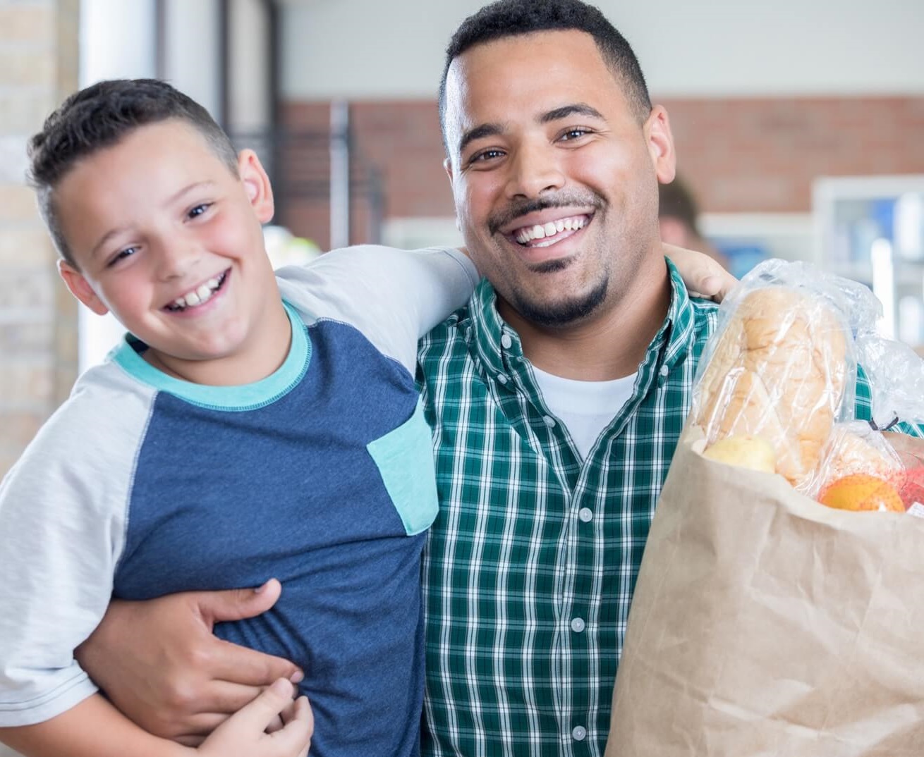 Father and son with bag of groceries.
