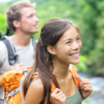 woman smiling while carrying a backpack