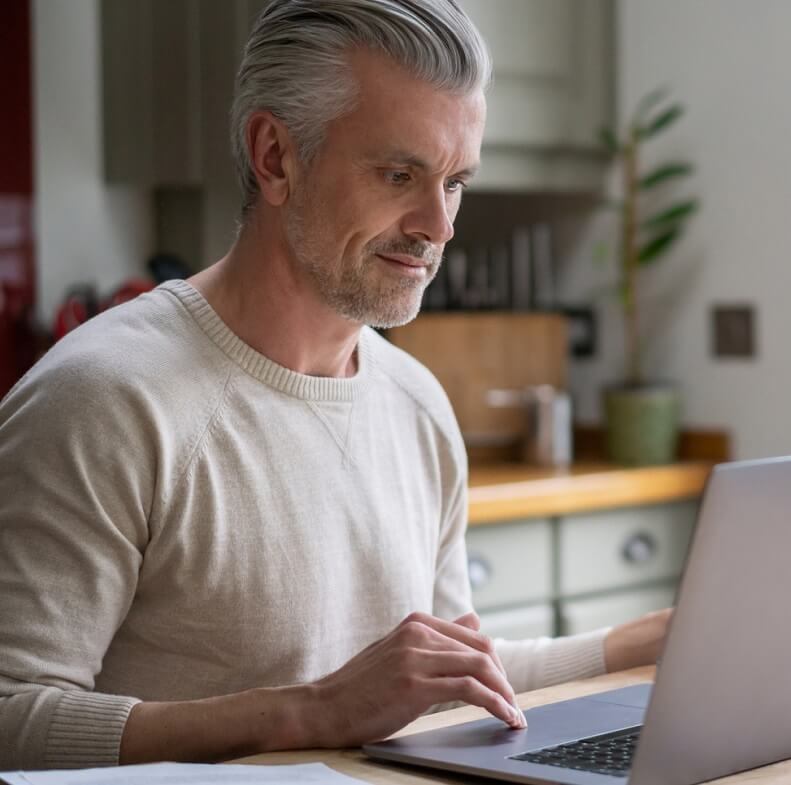 middle aged man using computer to look up information.