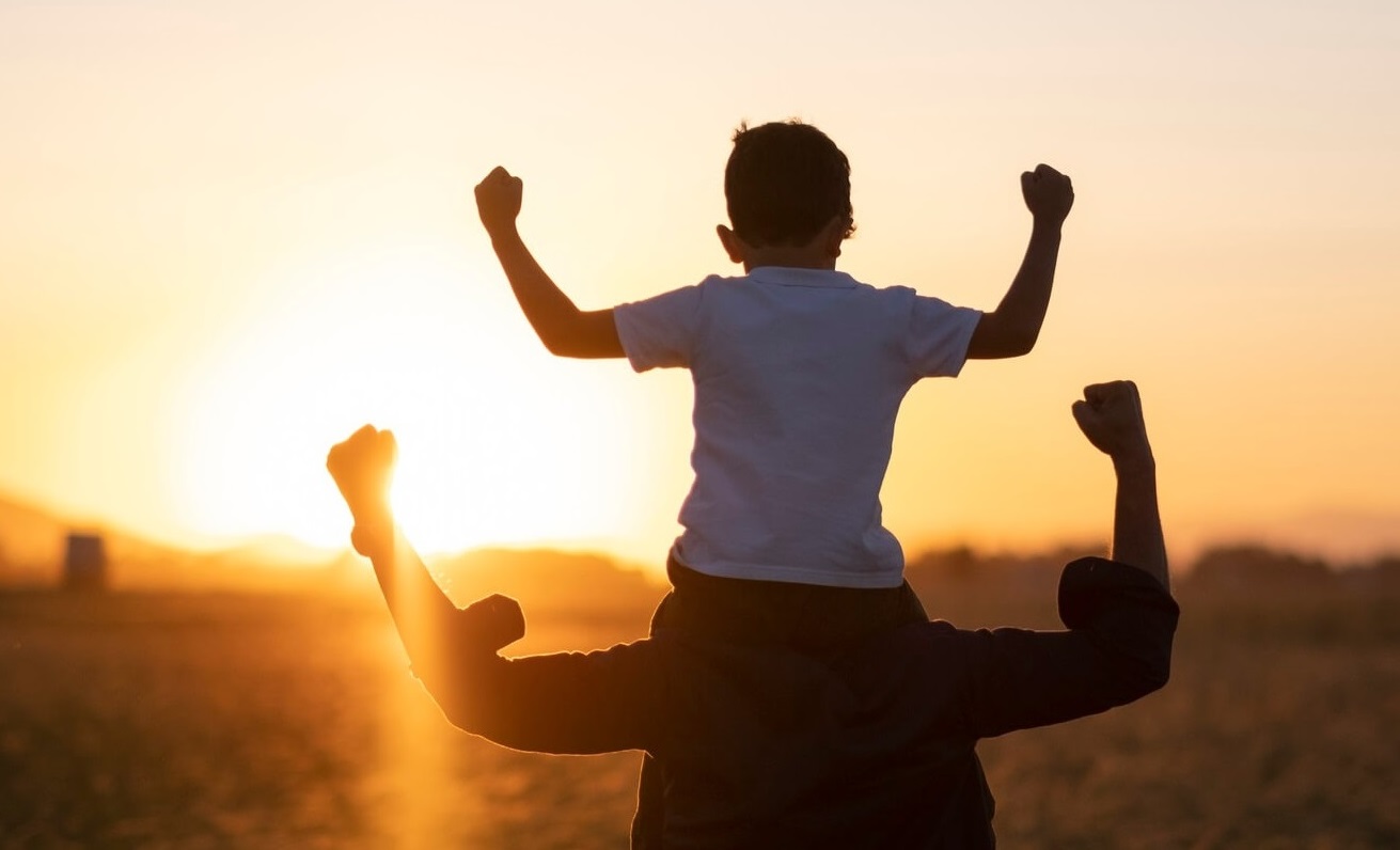 Adult and child flexing muscles and looking toward horizon.