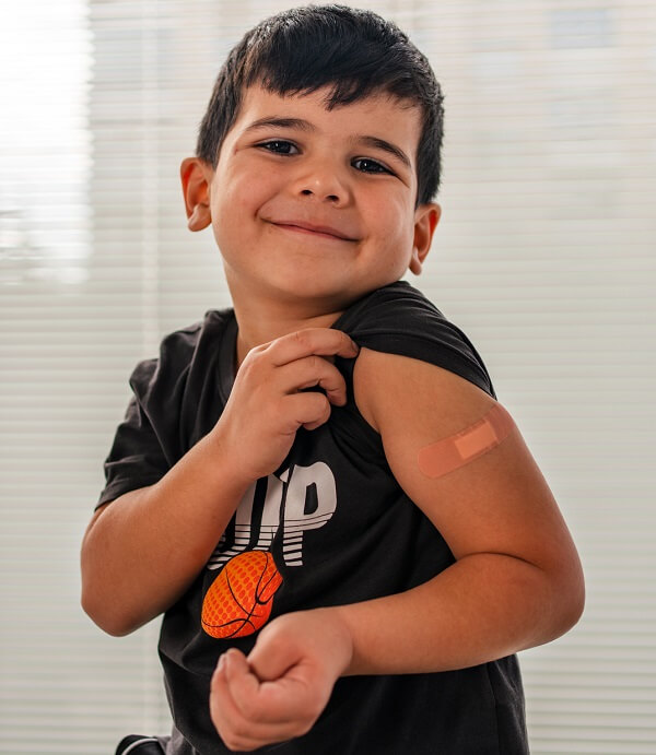 Little boy showing the bandaid from his flu shot
