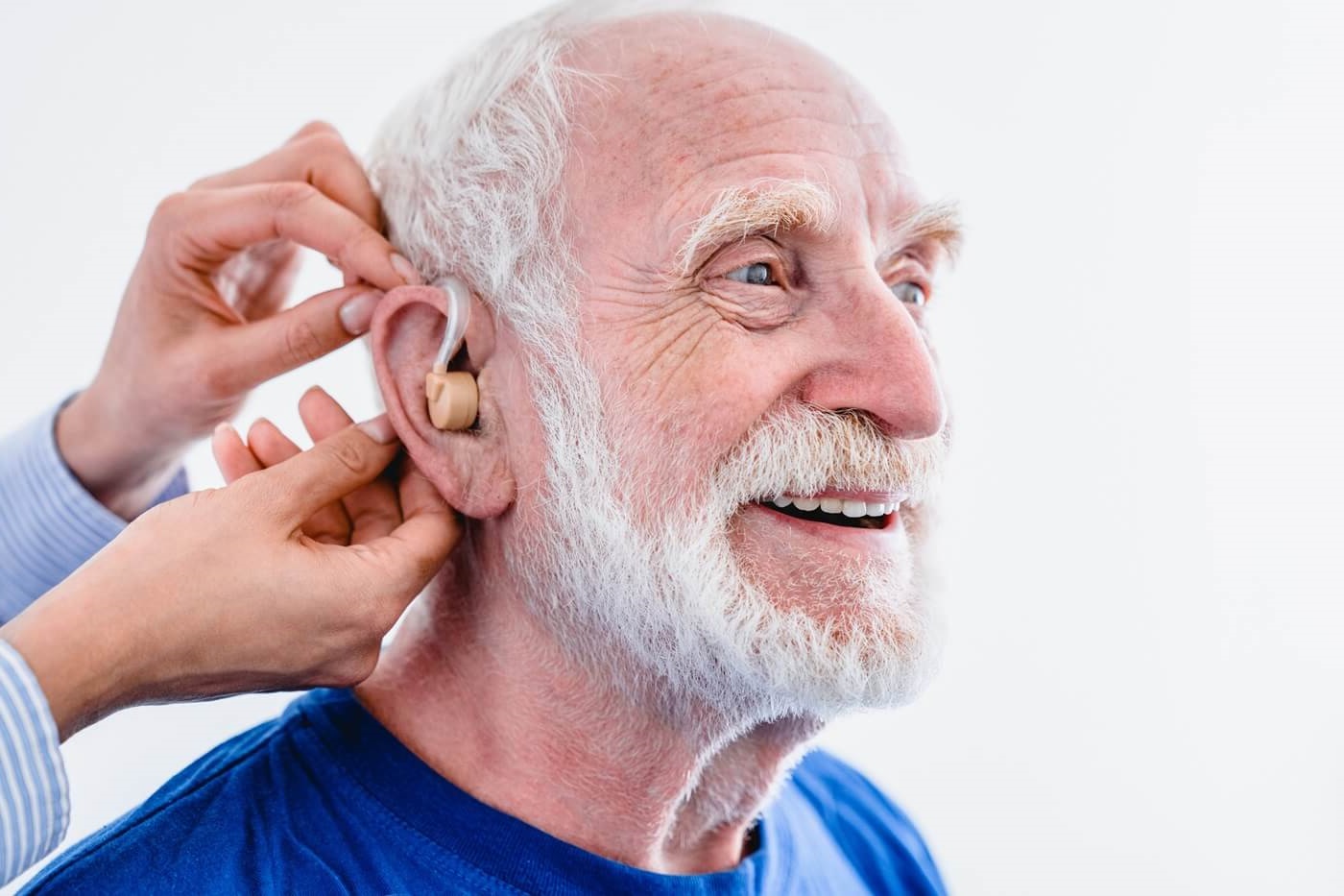 Senior man being fitted with hearing aids.