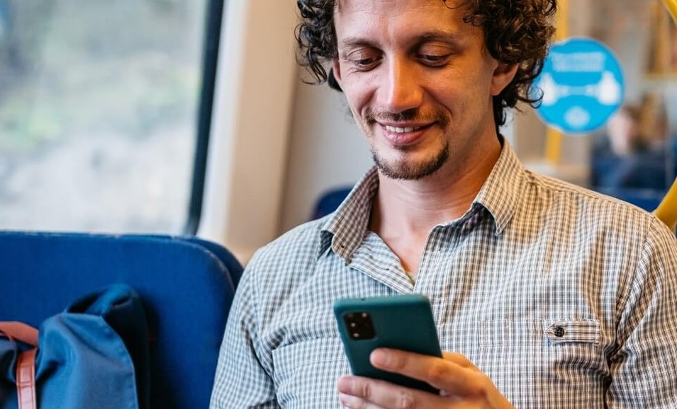 Man using his mobile phone while riding lightrail.