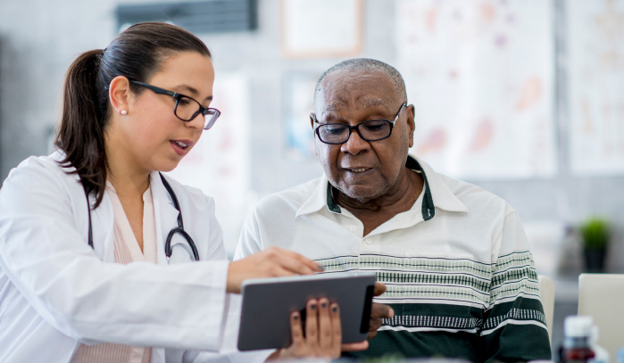 A provider shows a man something on a tablet