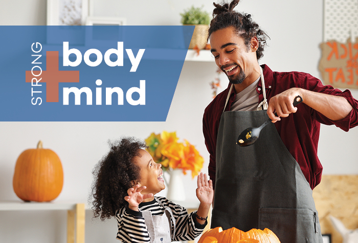 Photo of father and young son carving a pumpkin together.