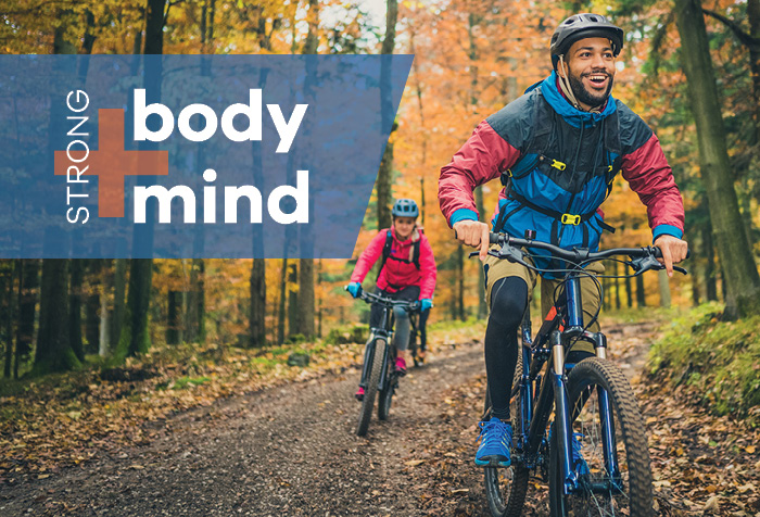 People riding bikes in autumn woods.