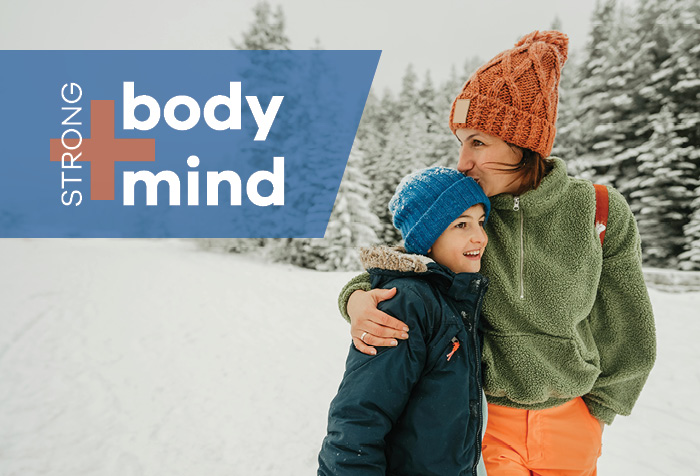 Mother hugging her son on outdoor walk in the snow