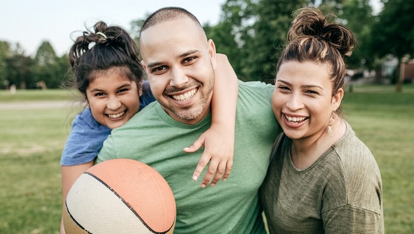 photo of Hispanic family playing ball in the park