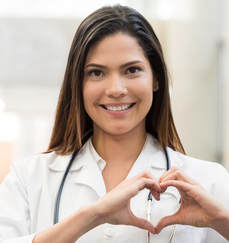 Photo of smiling health care provider making heart with hands.