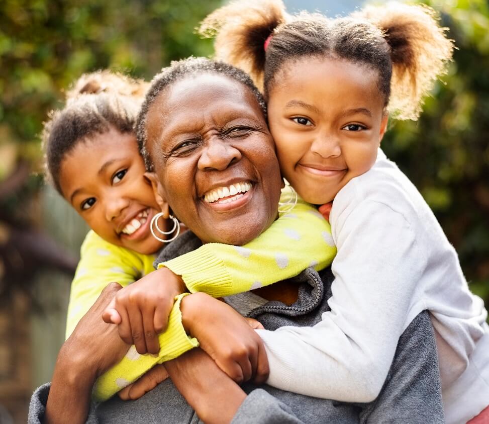 Photo of smiling grandmother with granddaughters.