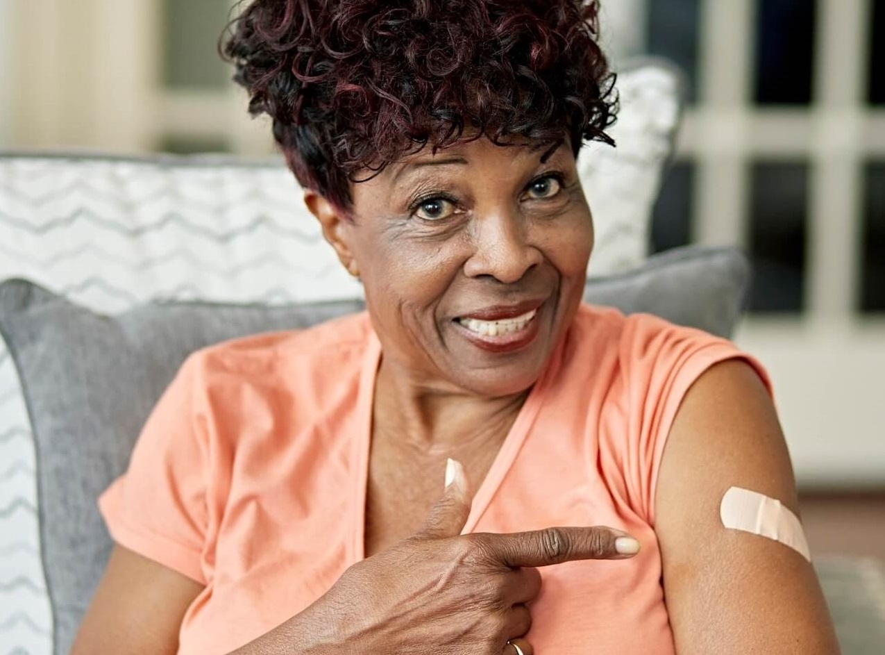 Photo of smiling woman showing that she got her vaccine.