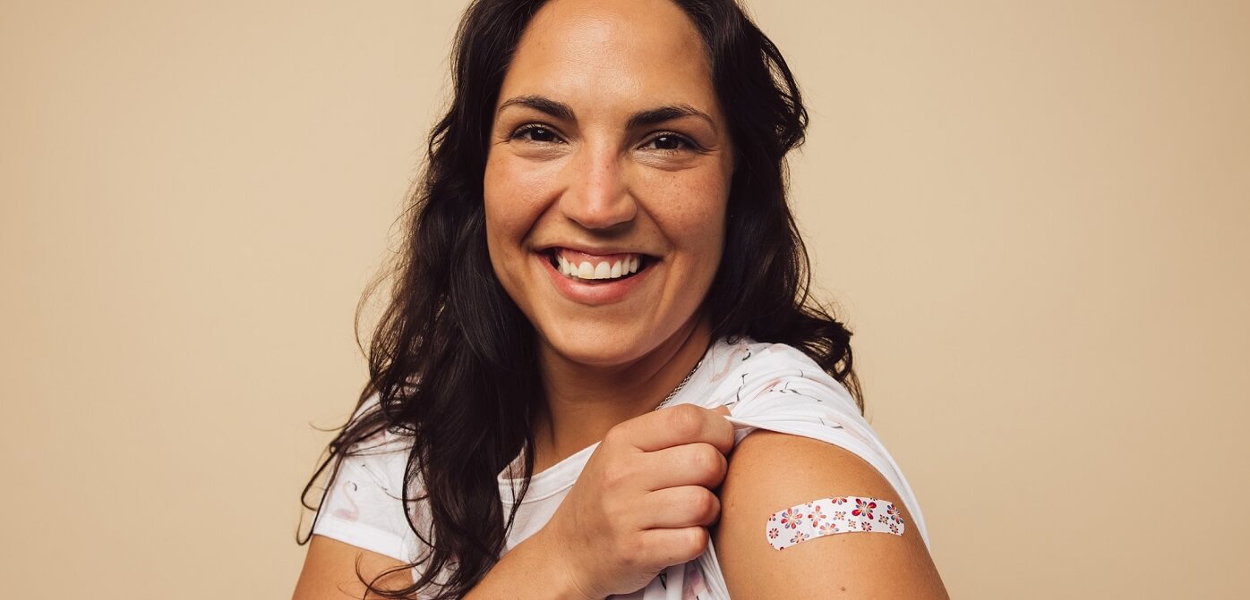 Photo of smiling woman showing that she got her vaccine.