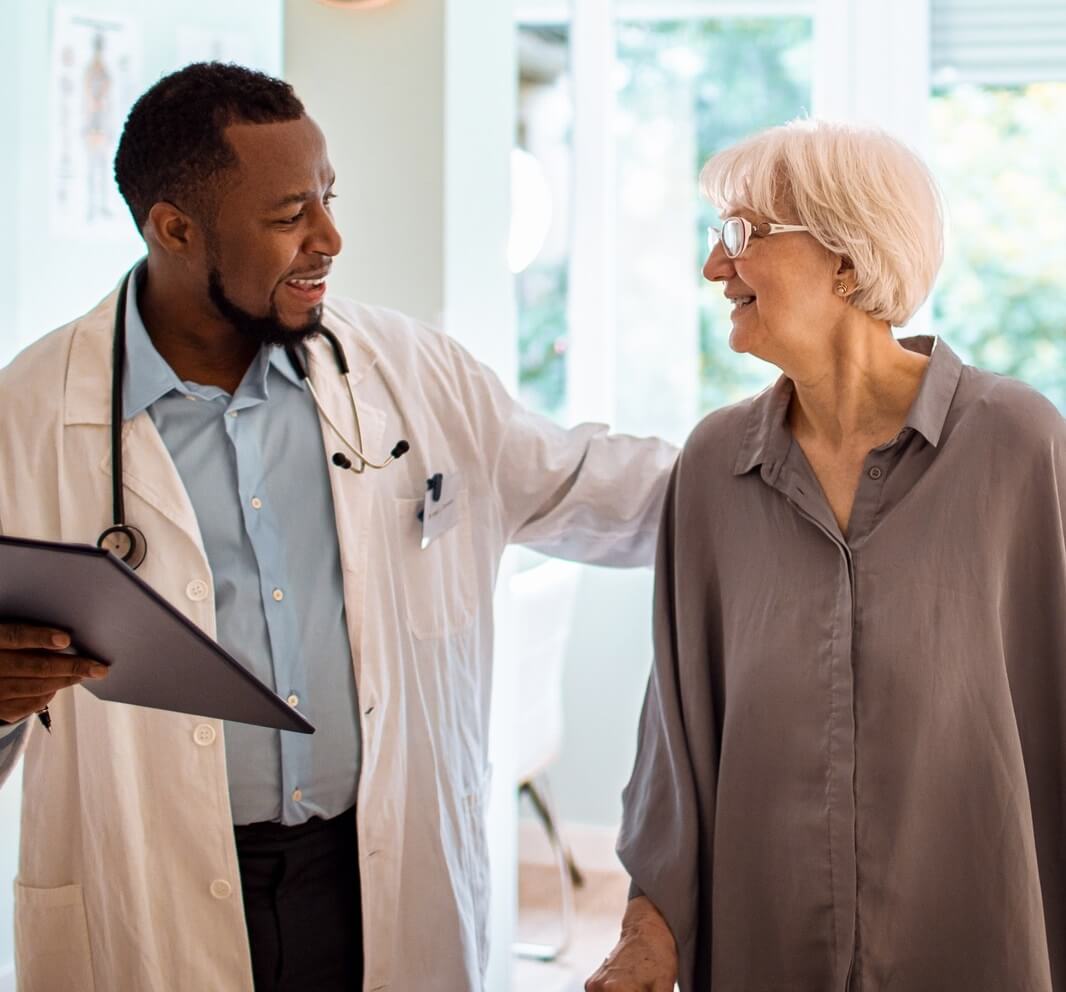 Photo of Medicare member walking and talking with her doctor.