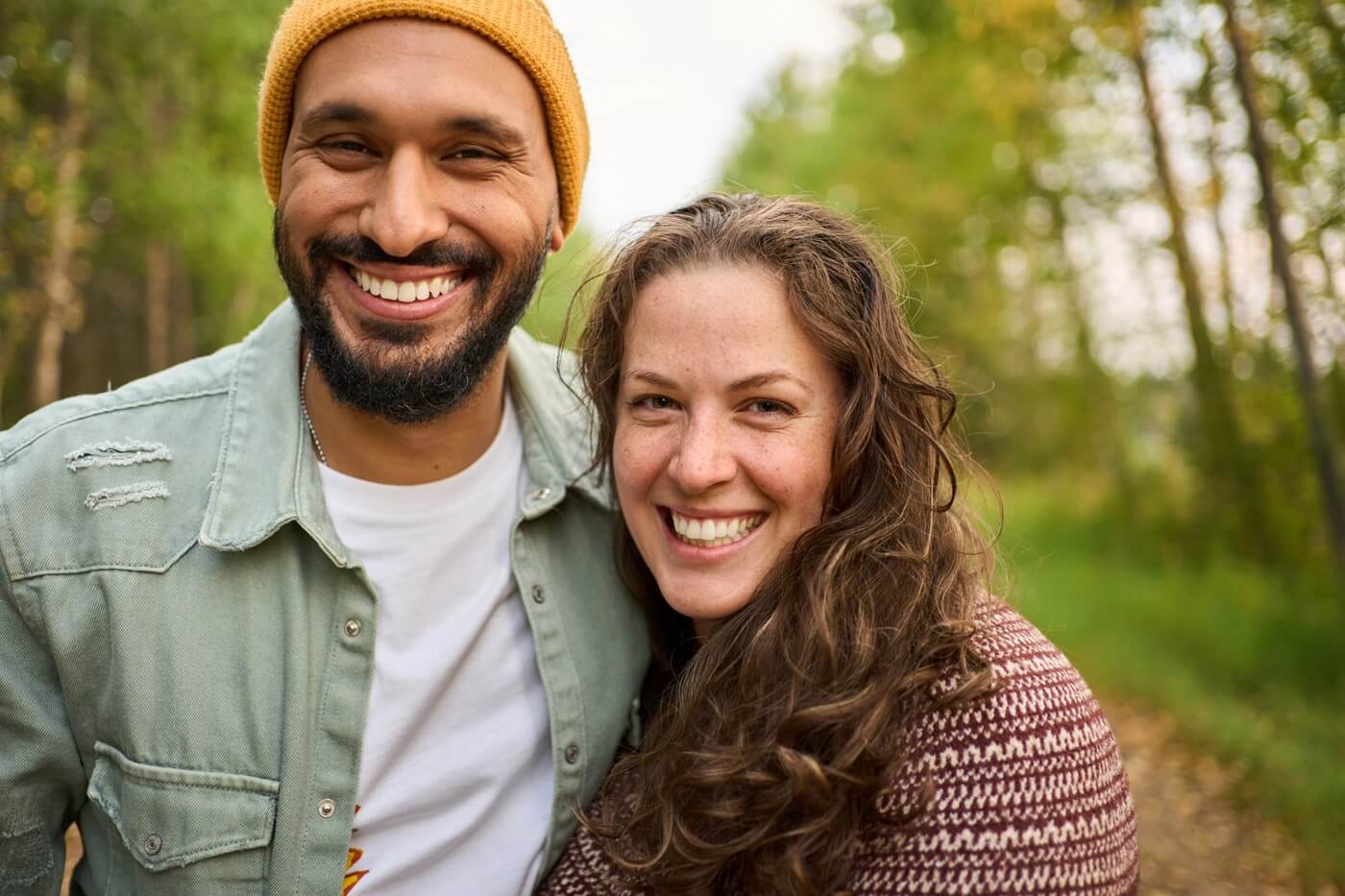 Smiling youn adult couple on trail walk outdoors