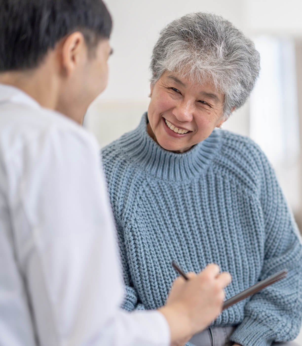 Smiling senior woman talking with health care provider.