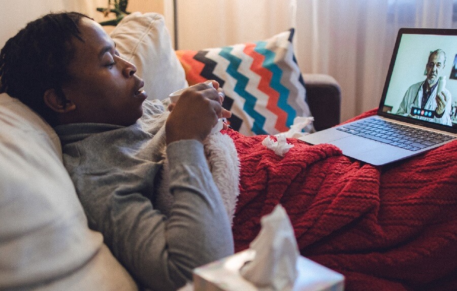 Young man with cold or flu on telehealth call with his doctor