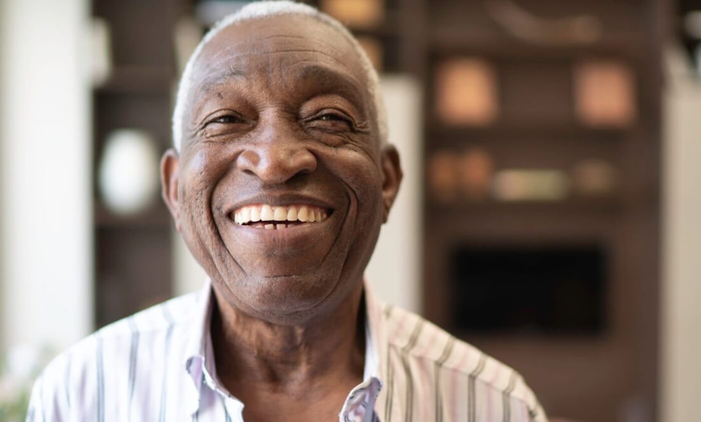 Senior man smiling widely.