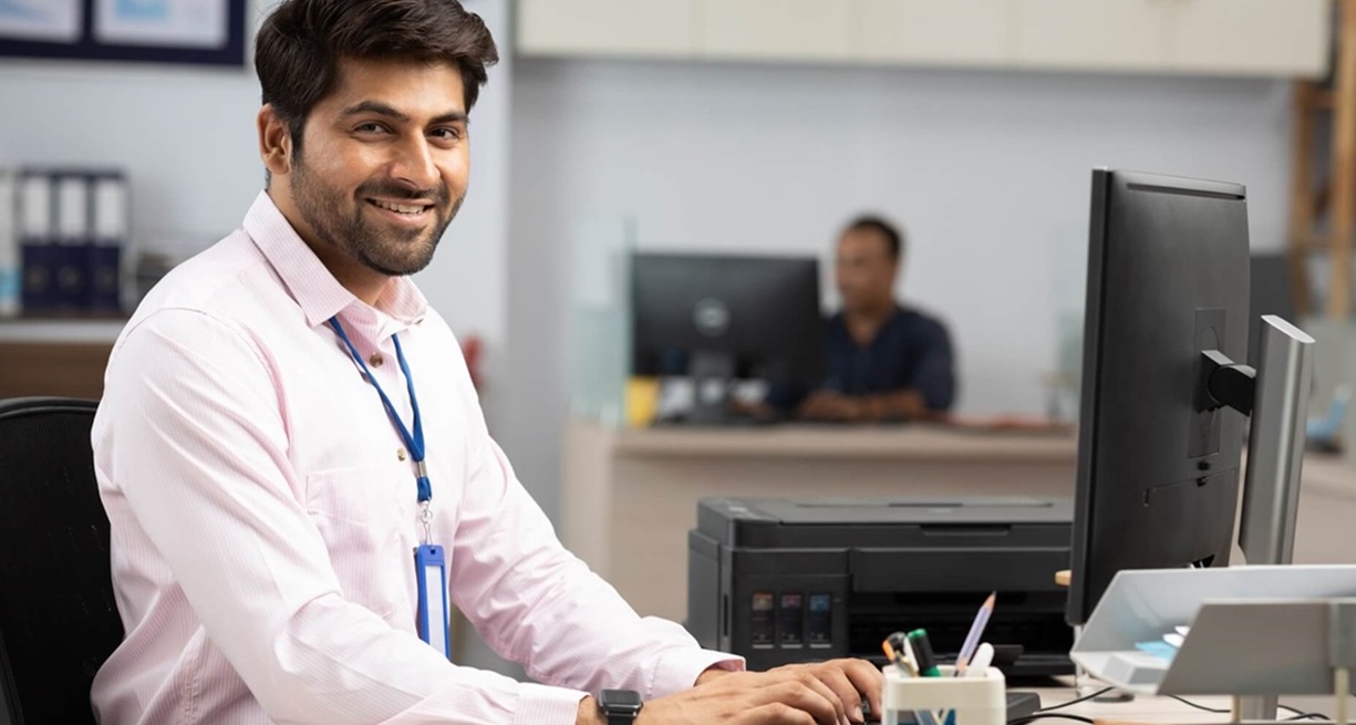 Provider facilty office staff member working at computer.