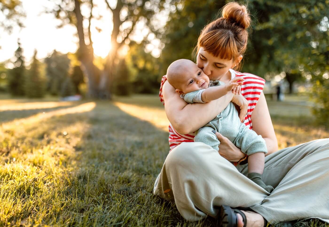Young mother holding her baby outdoors.