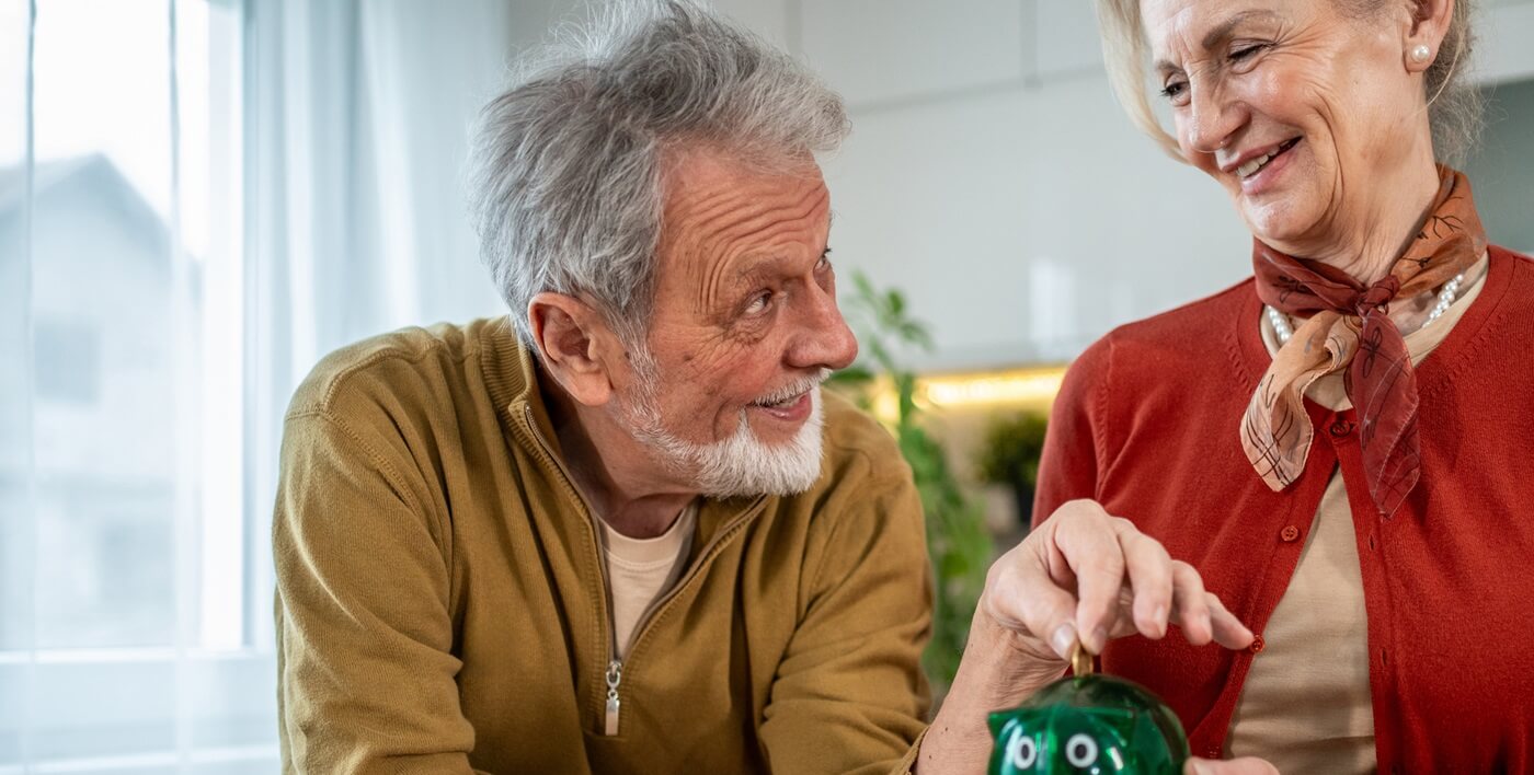 Senior couple saving money in jar.