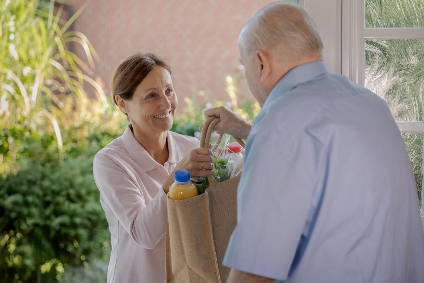 Senior man receiving home-delivered meal.