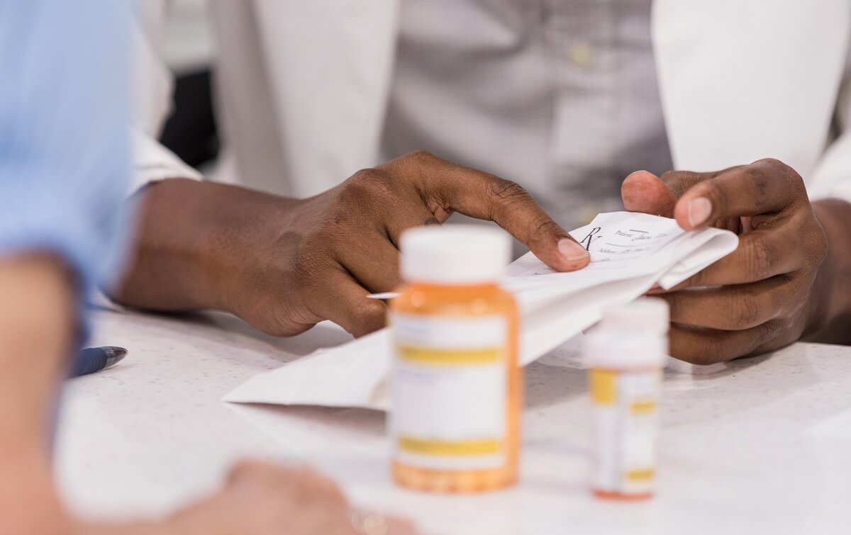 Photo of pharmacist explaining prescription instructions to patient.