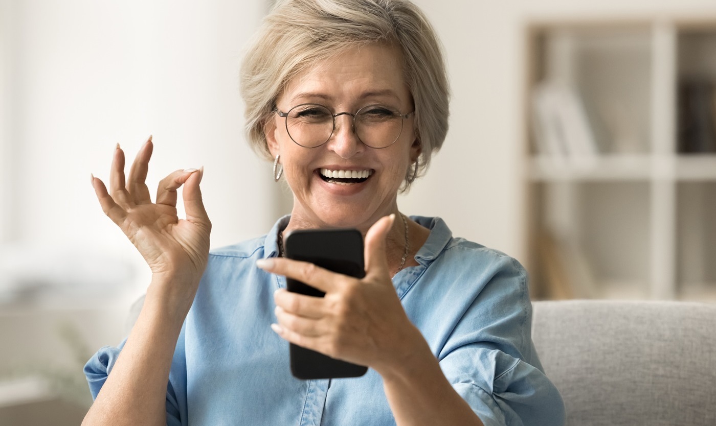 Happy senior woman using mobile phone.