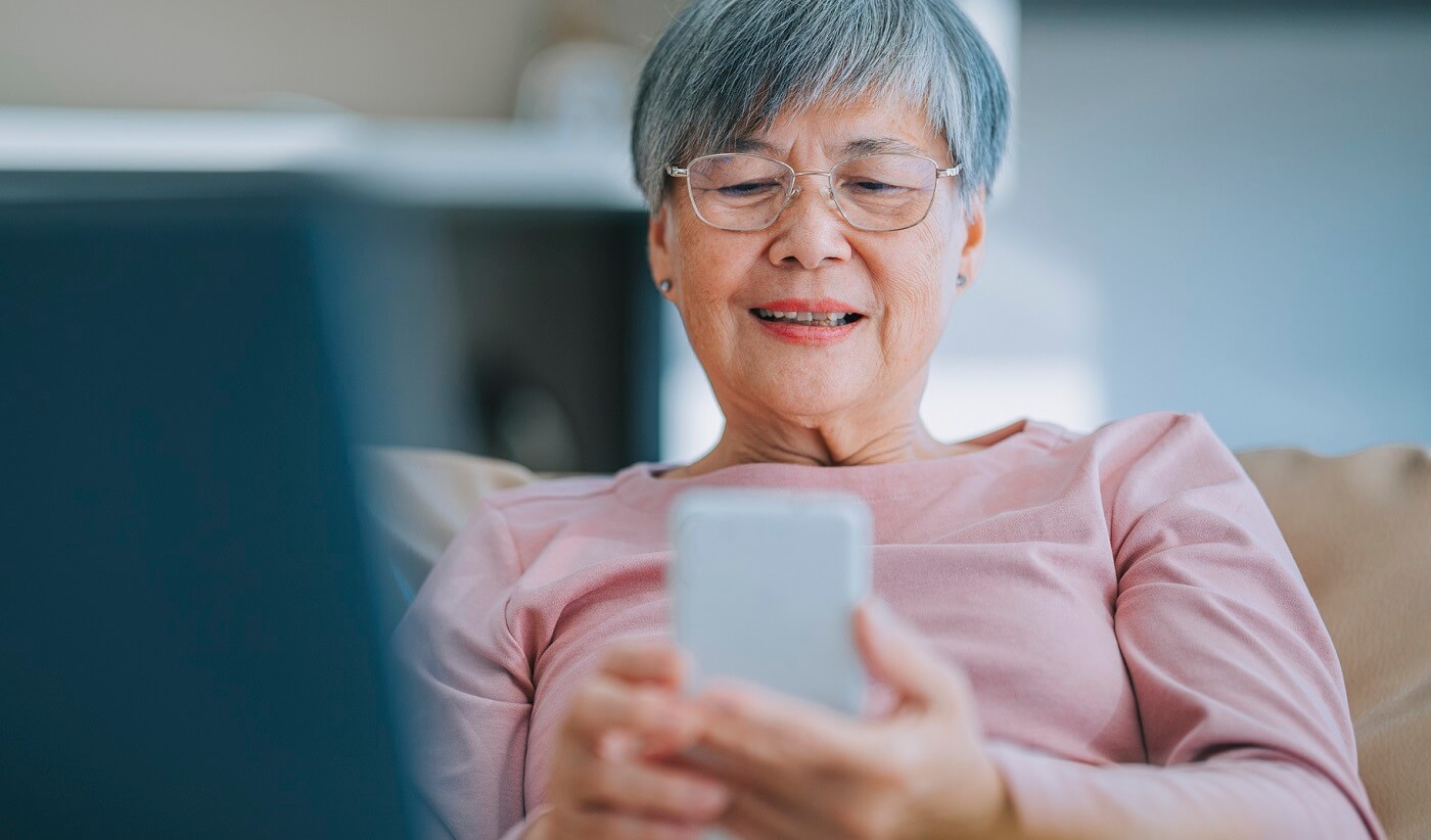 Photo of woman looking up her pharmacy information on her smartphone.