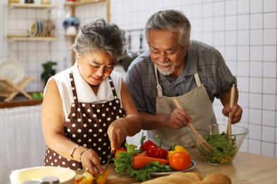 an elderly couple are cooking in their kitchen