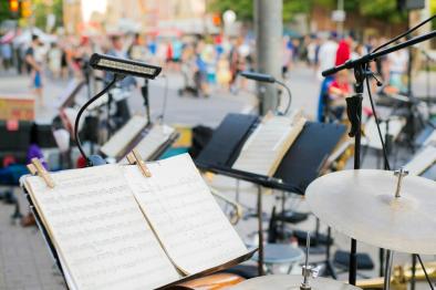 Photo of music stands and sheet music in outdoor venue.