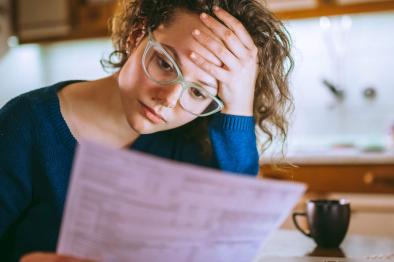 Concerned woman looking at a bill.