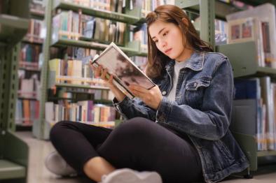 Photo of young woman reading at the library