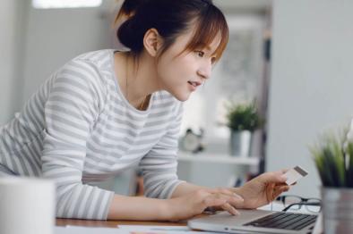 Photo of young woman paying bills on her laptop.