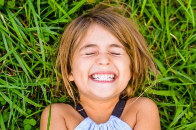 Photo of cute kid lying in the grass