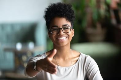 Photo of woman extending her hand in welcome gesture.